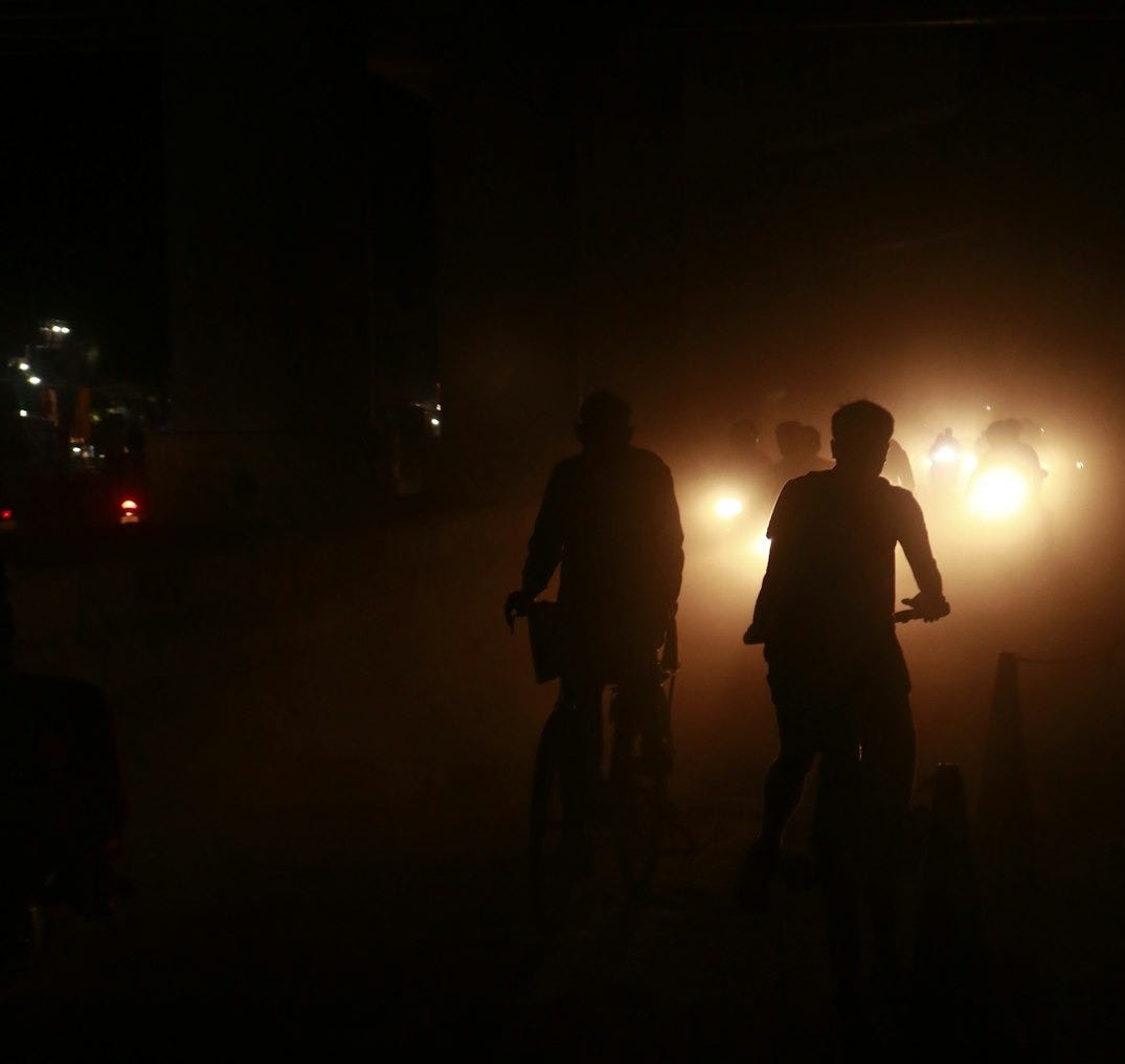 a couple of people riding bikes in the dark a couple of people riding bikes in the dark