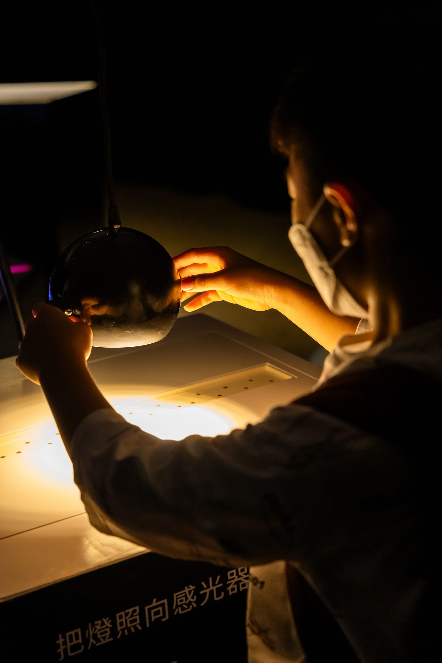 The interactive sound installation “Cave of Sounds” by Tim Murray-Browne and the Music Hackspace Ensemble, exhibited at Macao International Arts Festival. A boy directs a lamp onto an array of light sensors to control different harmonics of a fundamental. Photo: Instituto Cultural de Macau
