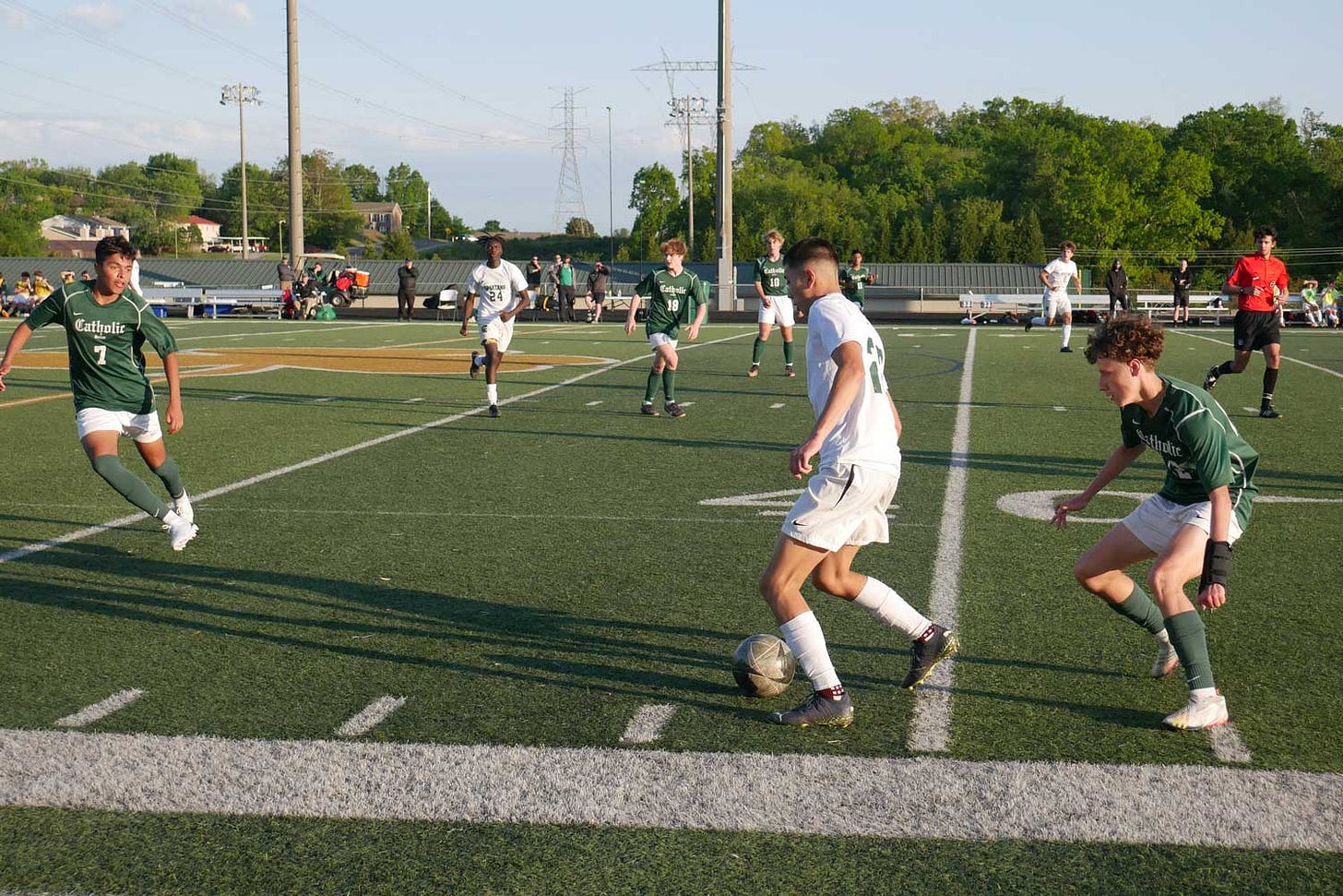 Knoxville Catholic and Webb boys soccer players compete on the field.