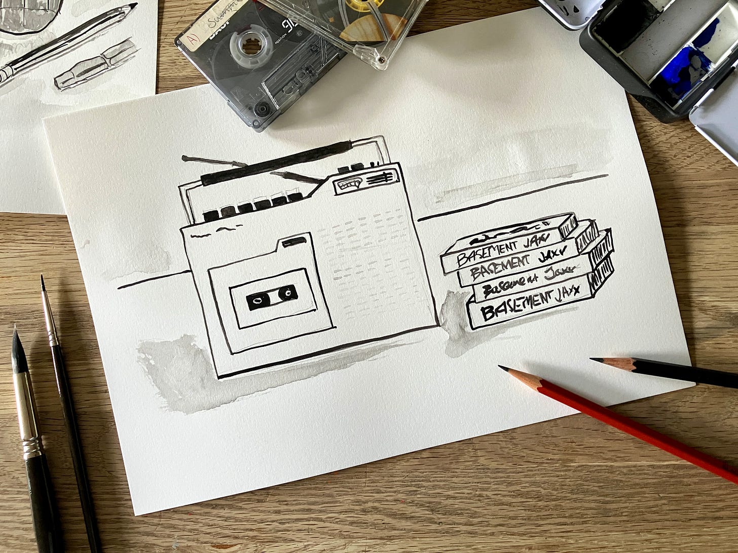 Painting of stereo and tapes surrounded by art materials sits atop a wooden table