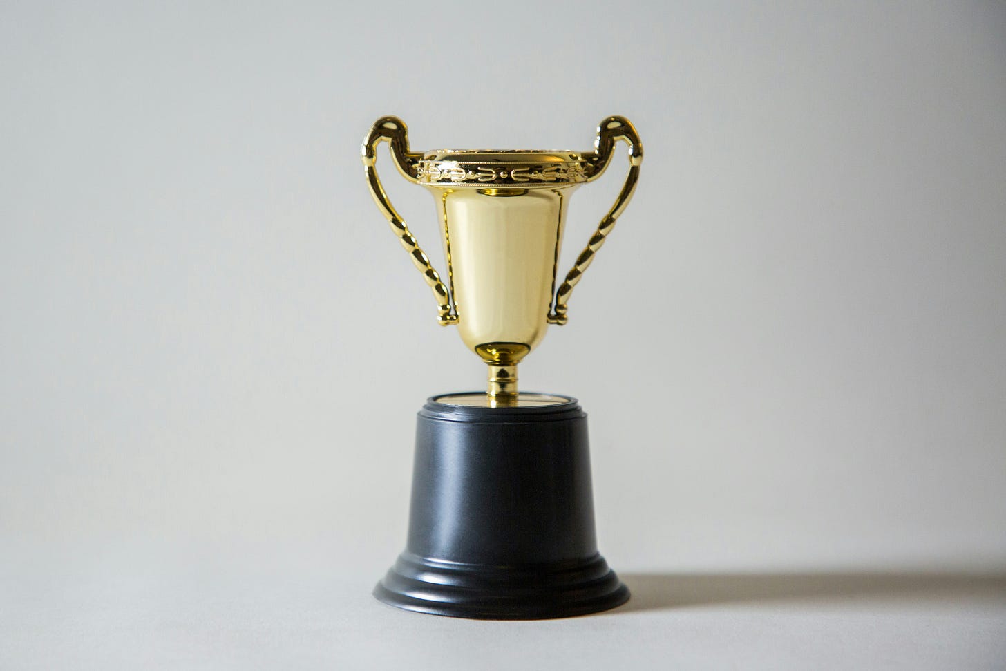 golden trophy with two handles, over a black base.