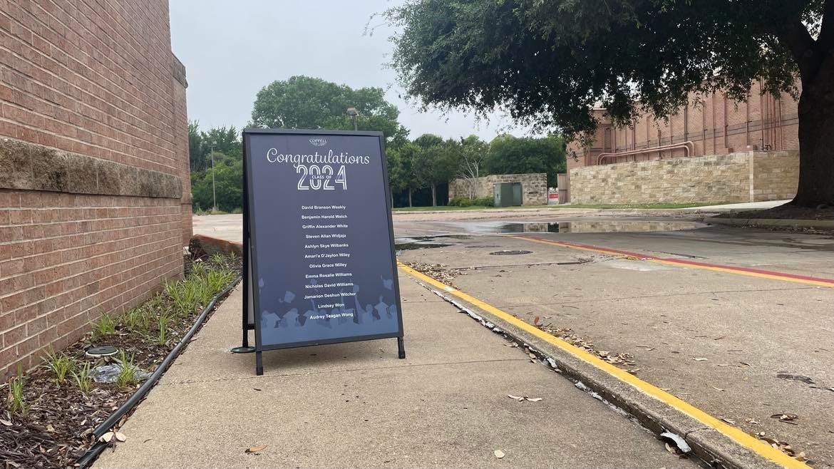 A sign bearing graduating seniors' names on a sidewalk