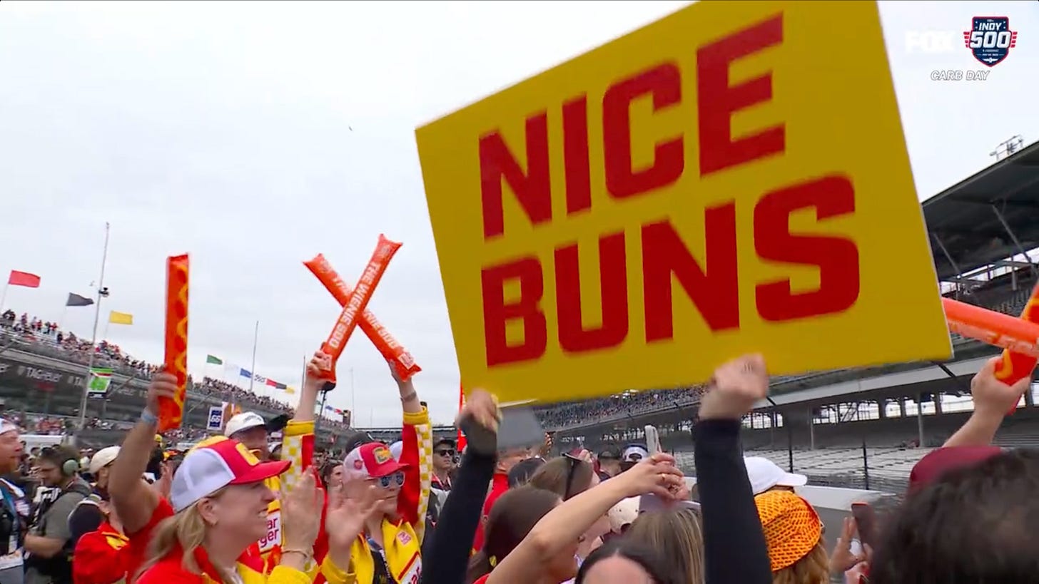 A crowd featuring a large sign that says "Nice Buns" A crowd featuring a large sign that says "Nice Buns"
