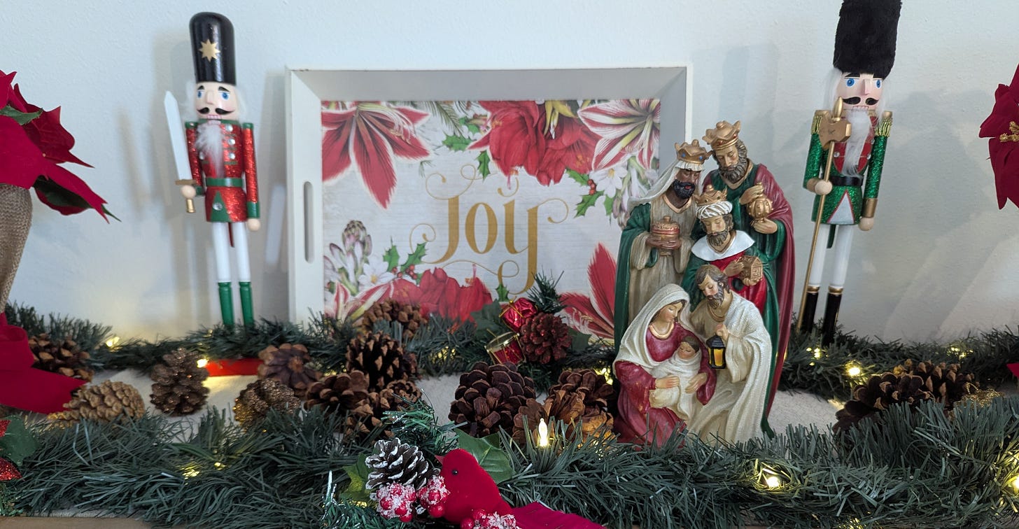 “A softly lit nativity scene with Mary, Joseph, and baby Jesus, surrounded by greenery and Christmas decorations."