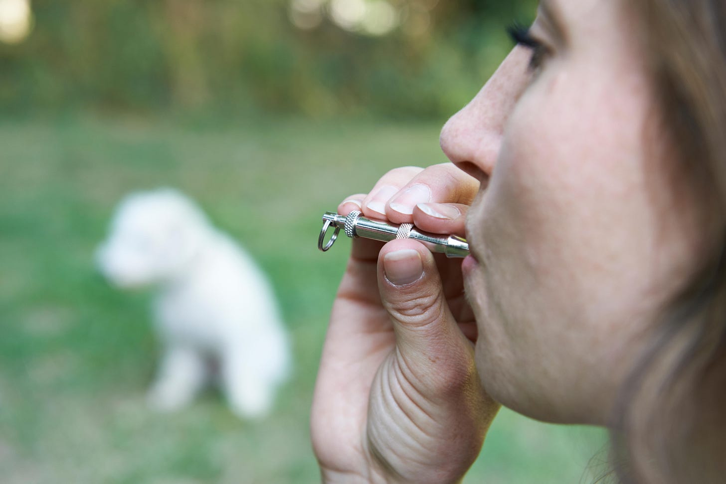 Woman blowing dog whistle
