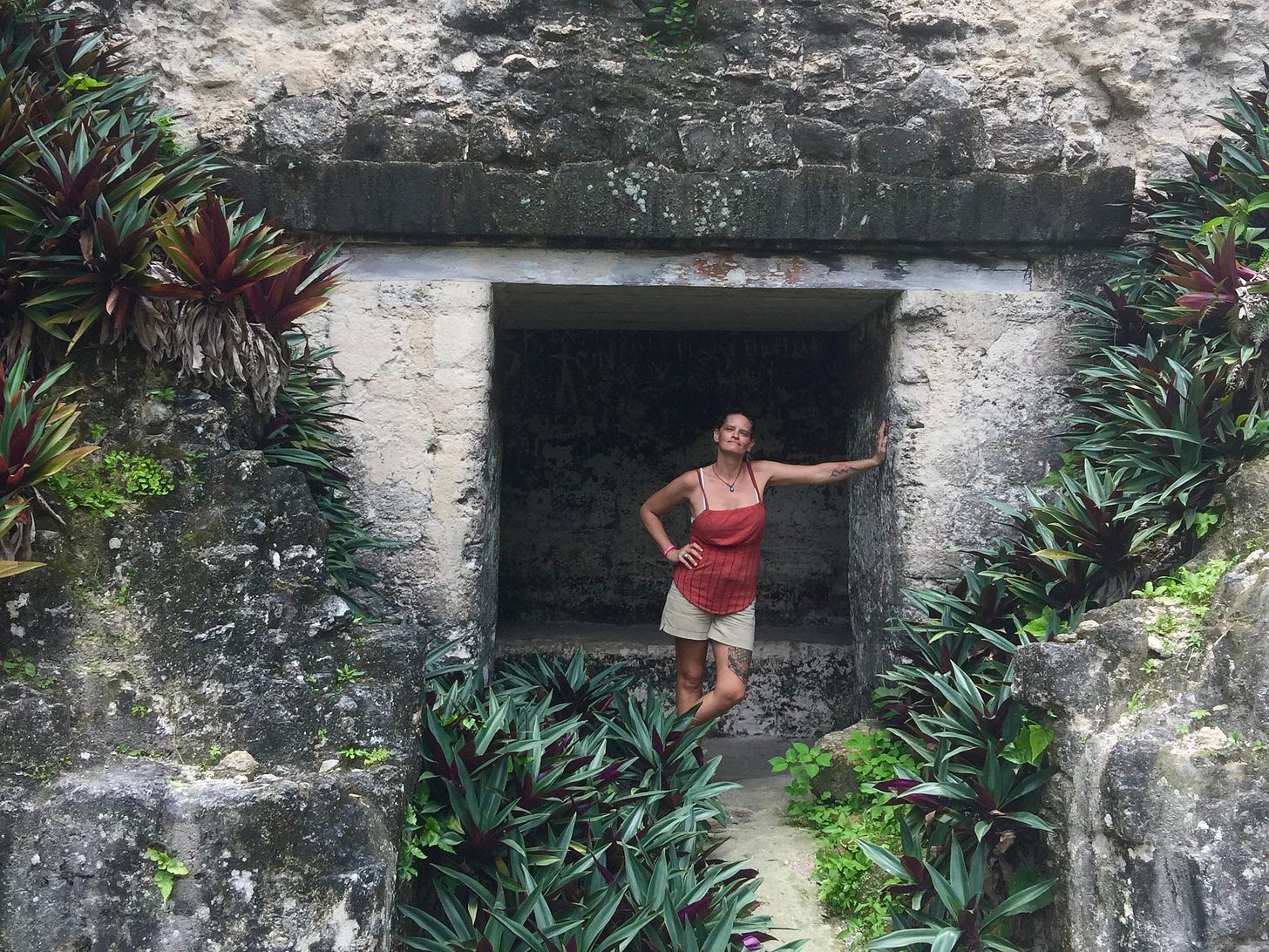 Author stands inside a stone doorway of a Mayan temple in Guatemala