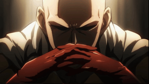 a bald man with his hands folded looks angry