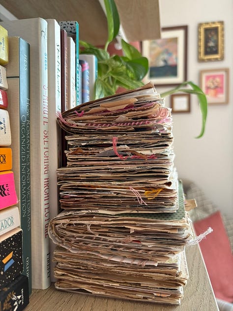 Stacks of art journals on my bookshelves.