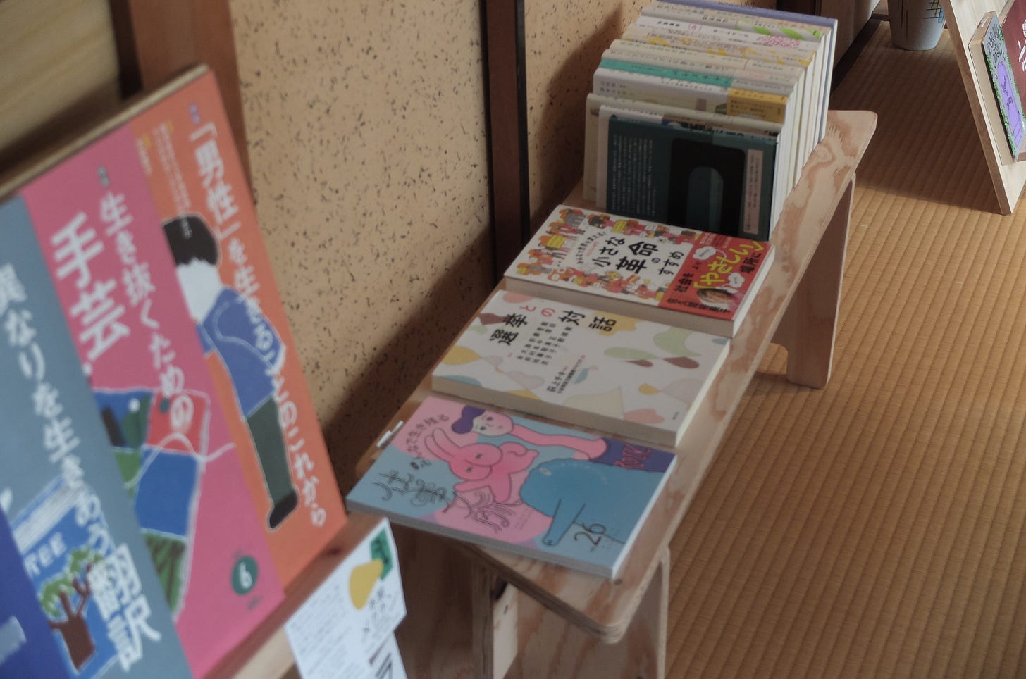 店内の入口付近の画像。畳敷の床の上にある背が低い本棚の上に本が陳列されている。