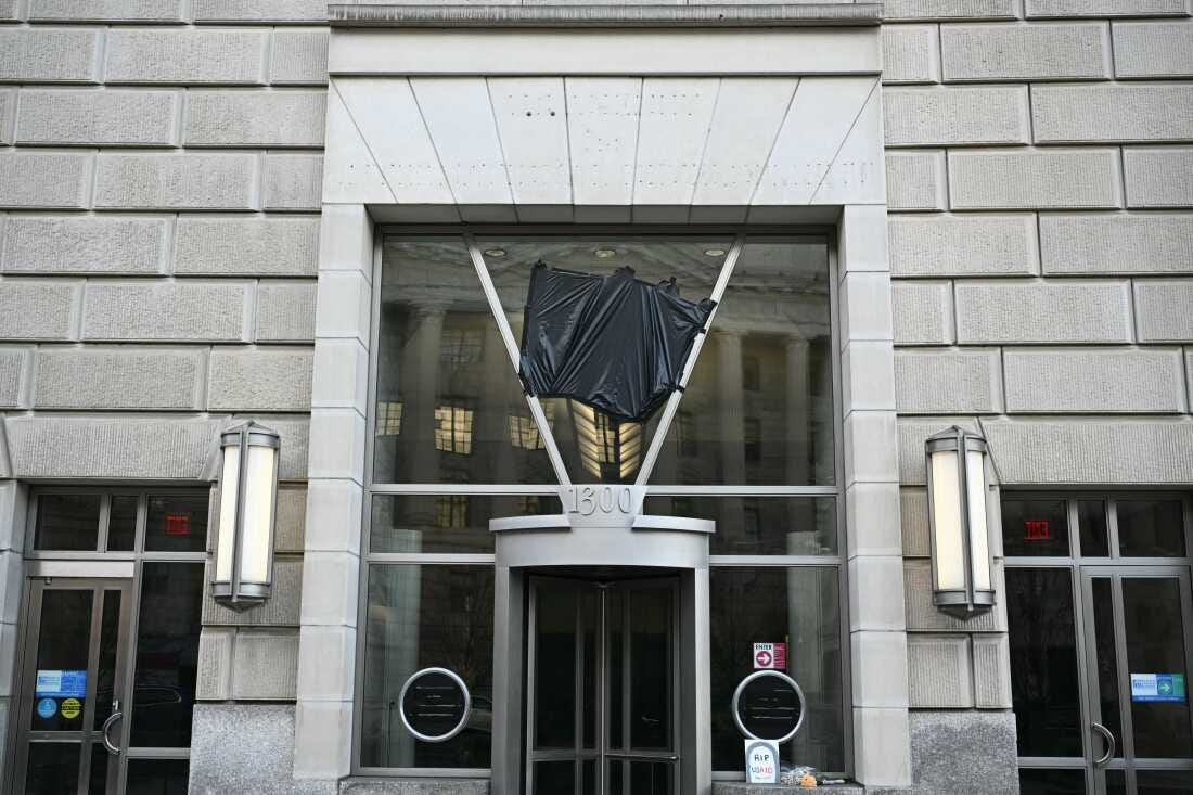 Holes are seen on the building after signage was removed (top) while black plastic covers the logo of the United States Agency for International Development (USAID) at its headquarters in Washington, DC, on February 7, 2025. President Donald Trump on February 7 called for USAID to be shuttered, escalating his unprecedented campaign to dismantle the humanitarian agency.