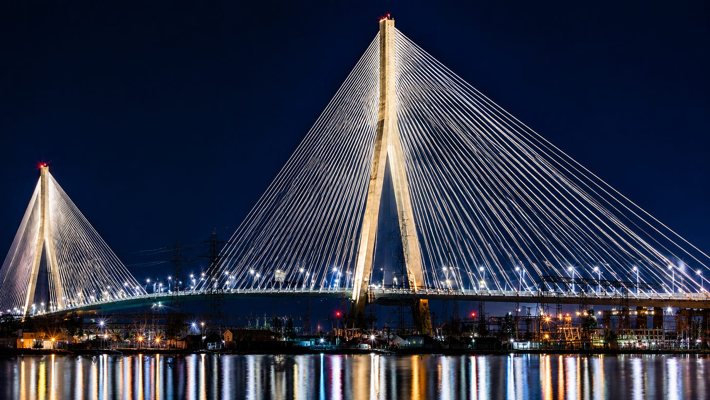 Aerial view of the Gordie Howe Bridge spanning the Detroit River at sunset