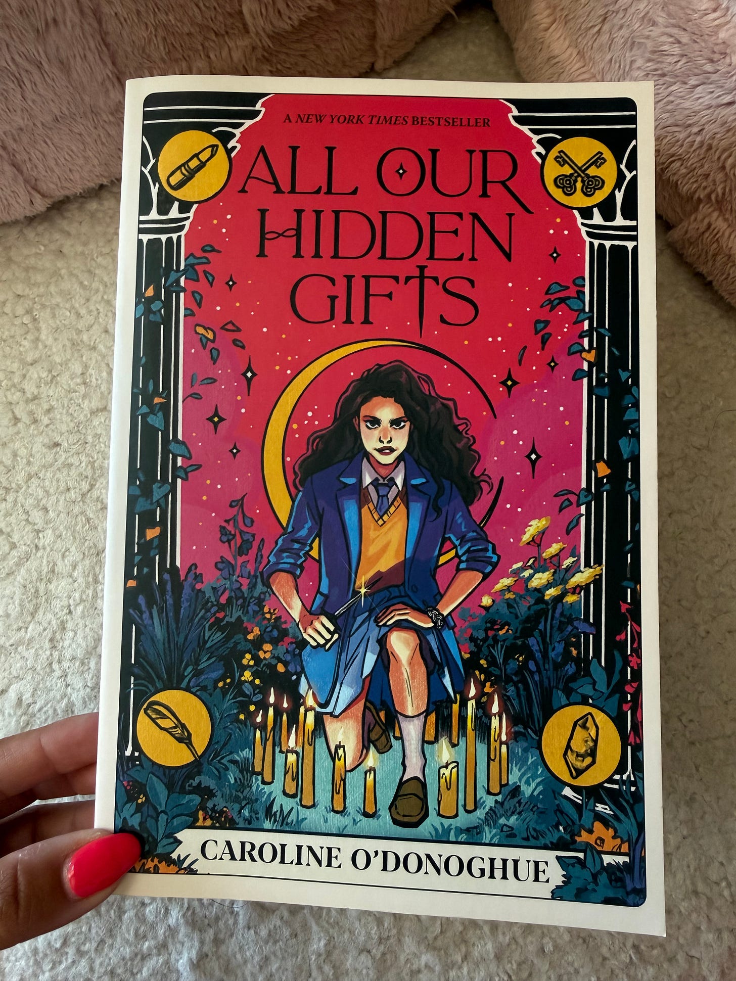 A hand holding the book cover of All Our Hidden Gifts by Carolyn O'Donoghue A hand holding the book cover of All Our Hidden Gifts by Carolyn O'Donoghue