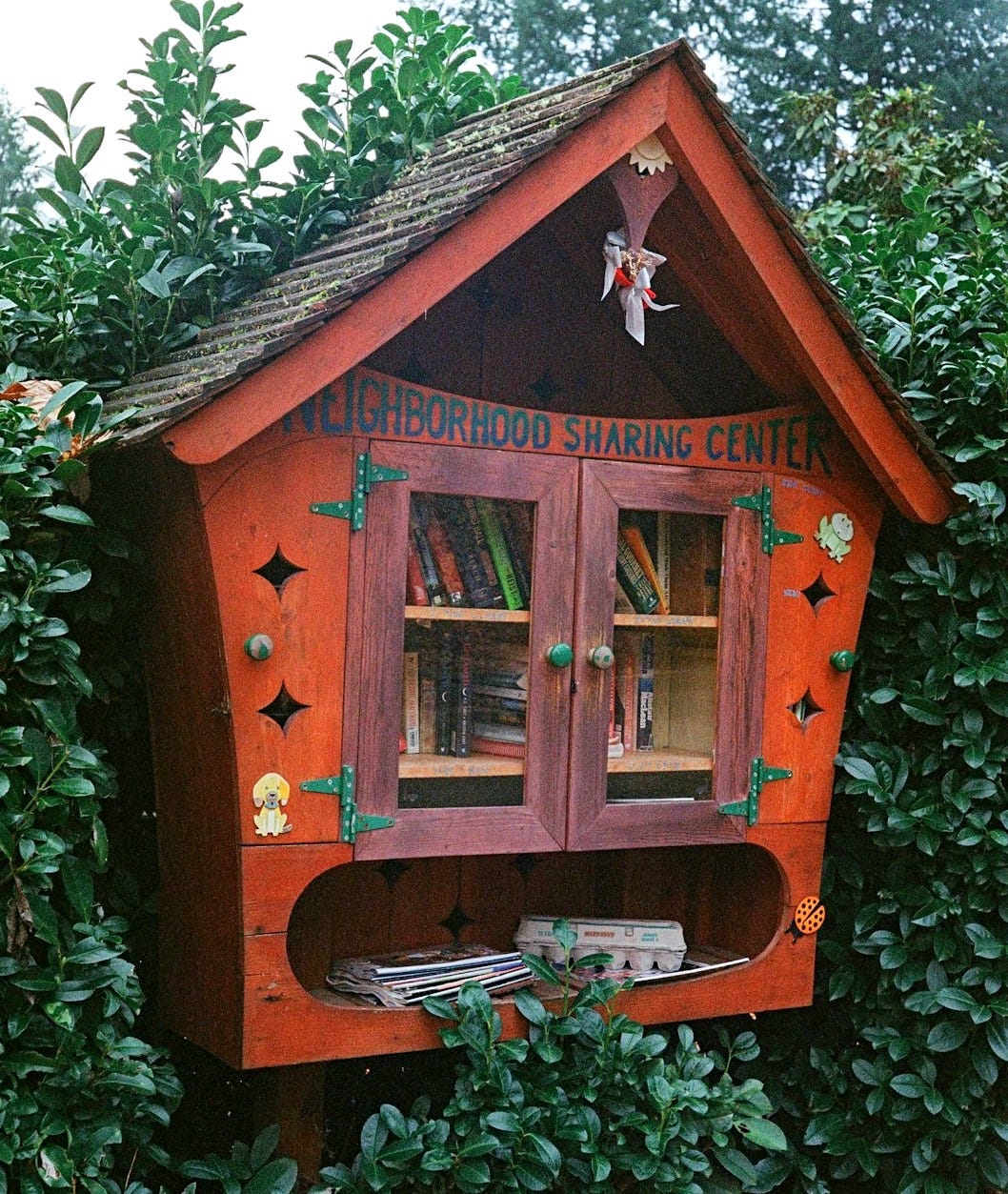 a small wooden house with a book shelf inside of it
