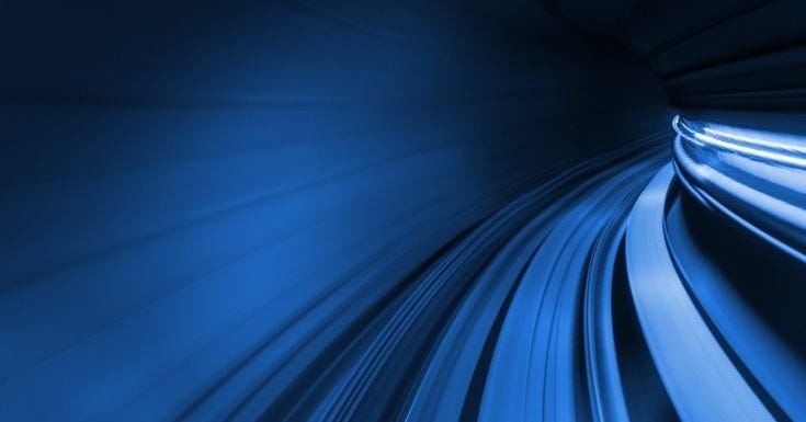 This may contain: a blue tunnel with light streaks going through it