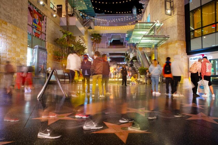 Hollywood, CA - March 20: People blur by the Hollywood and Highland shopping complex along Hollywood Blvd, in the heart of Hollywood, CA, as COVID-19 restrictions are loosened and people filled the sidewalks Saturday, March 20, 2021. This is one year and one day, after California Gov. Gavin Newsom issued a stay at home order, "to protect the health and well-being of all Californians and to establish consistency across the state in order to slow the spread of COVID-19." As of March 19, 2021, 57,510 people died from the coronavirus, with more than 3million positive cases. (Jay L. Clendenin / Los Angeles Times)