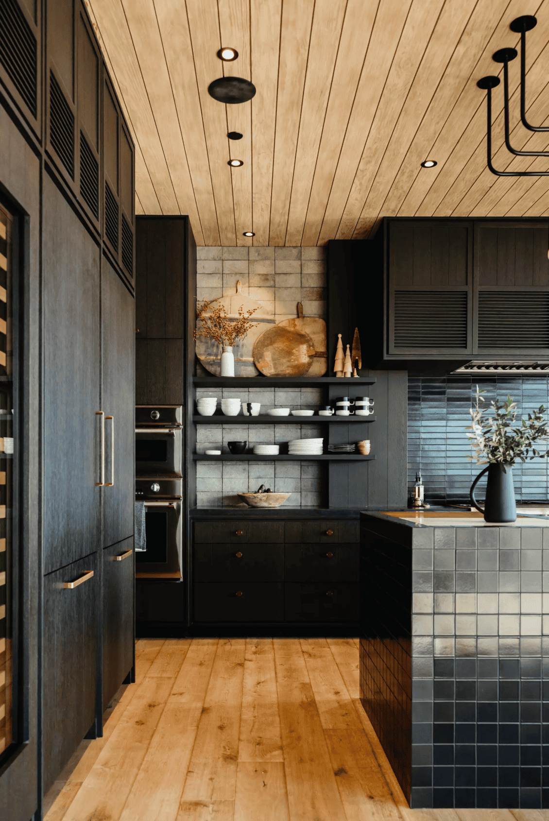 small kitchen design mistakes, all black reflective kitchen with shiny tiles and oak ceiling. 