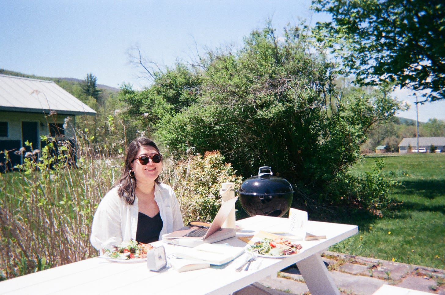 Nicole writing at a picnic table on a sunny day