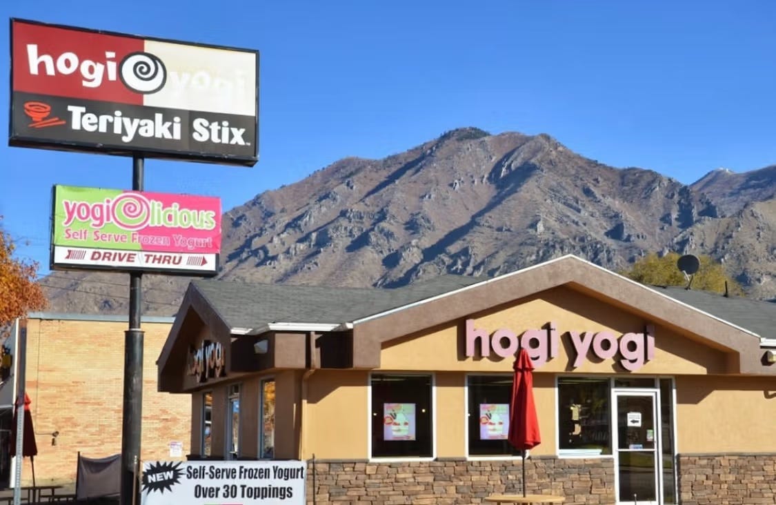 A picture of a hogi yogi restaurant in the foreground and beautiful foothills of the west in the background with a clear, bright blue sky.