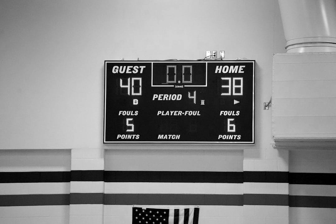 a scoreboard in a gym with a flag on the floor