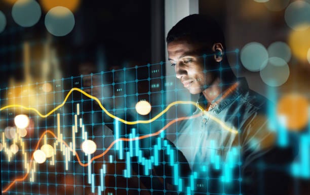 Shot of a handsome young businessman using a digital tablet while working late in his office It's time you also get connected fintech stock pictures, royalty-free photos & images