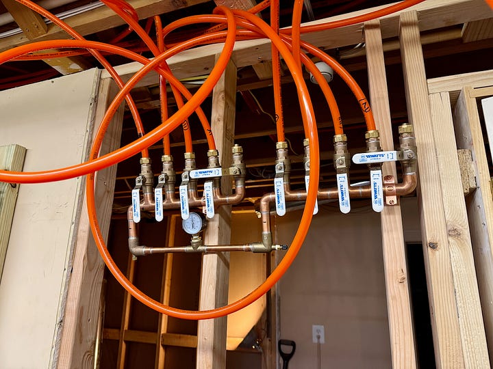 Two photos showing PEX connected to a distribution manifold.
