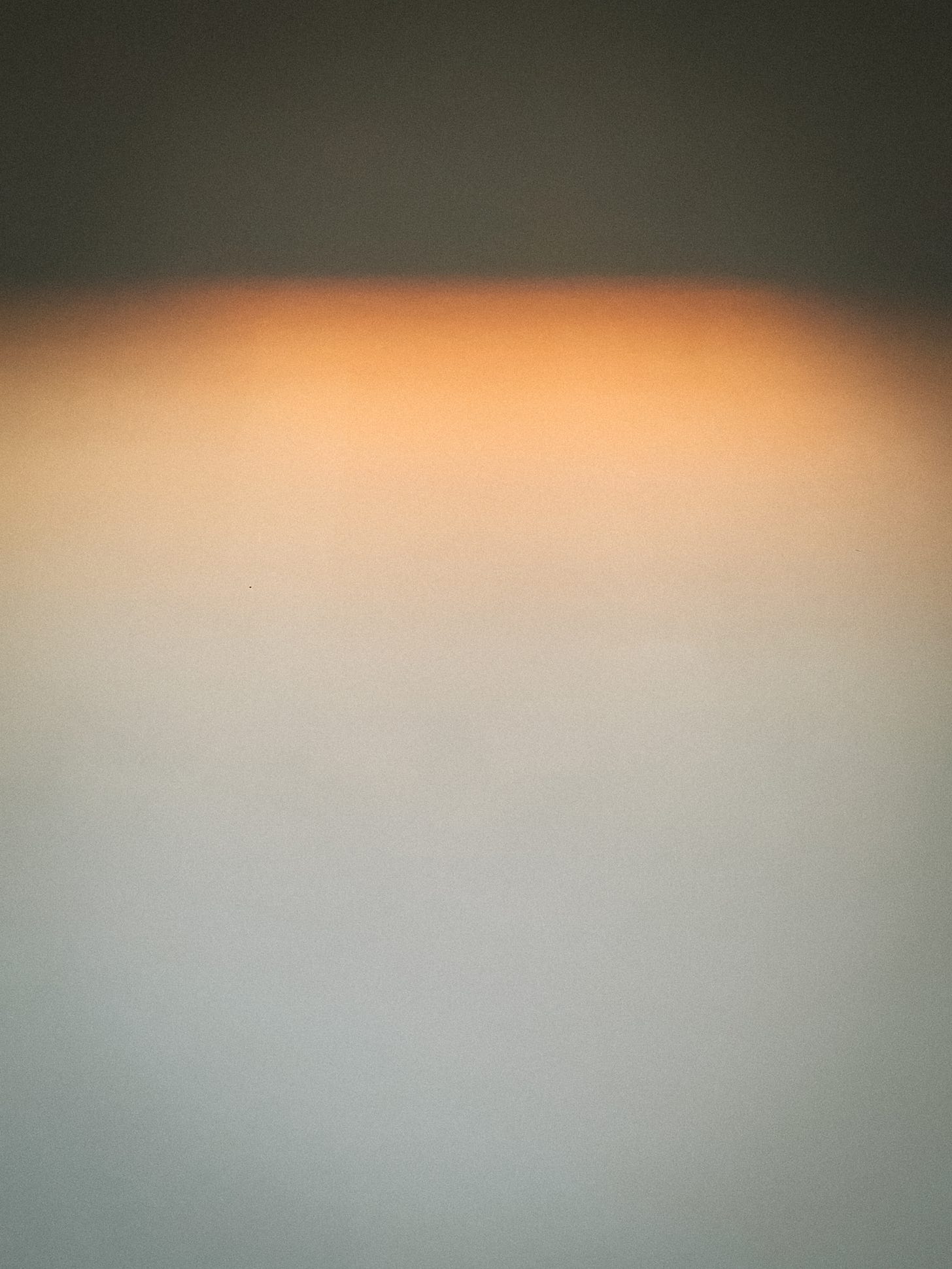A gradient of orange on a white wall. A gradient of orange on a white wall.