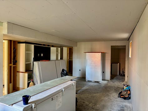 Three images show drywall being installed in a basement refinishing project.