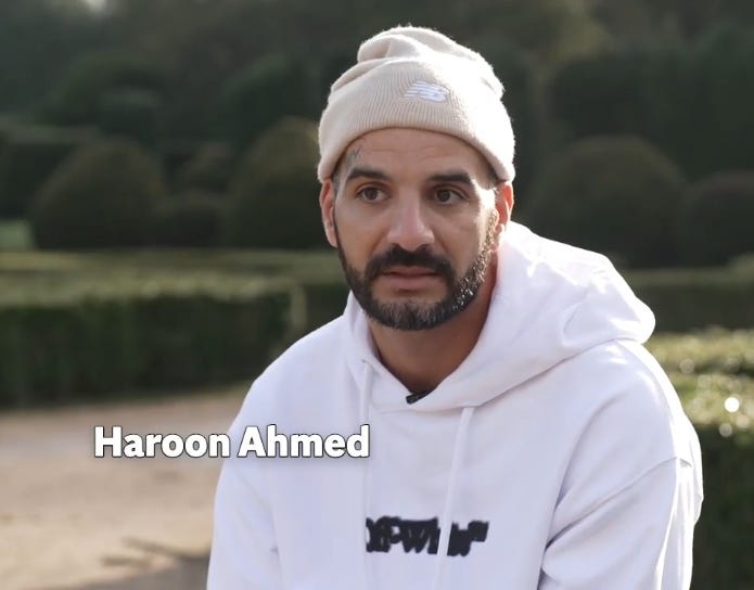 Man in his thirties seated in garden speaking to camera