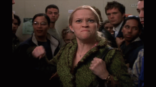 a woman in a crowd says me in front of a group of people