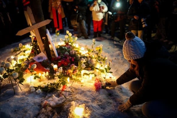 A person adds to a memorial A person adds to a memorial