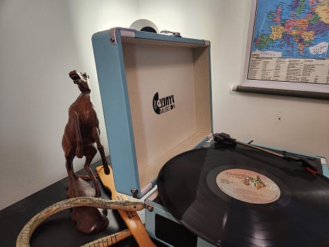 Carved horse, wooden snake, record player, wall map, dragon kite, games, brass lamp, Lego flowers, mirror, globe, lava lamp, books, football player figures, hourglass, typewriter.