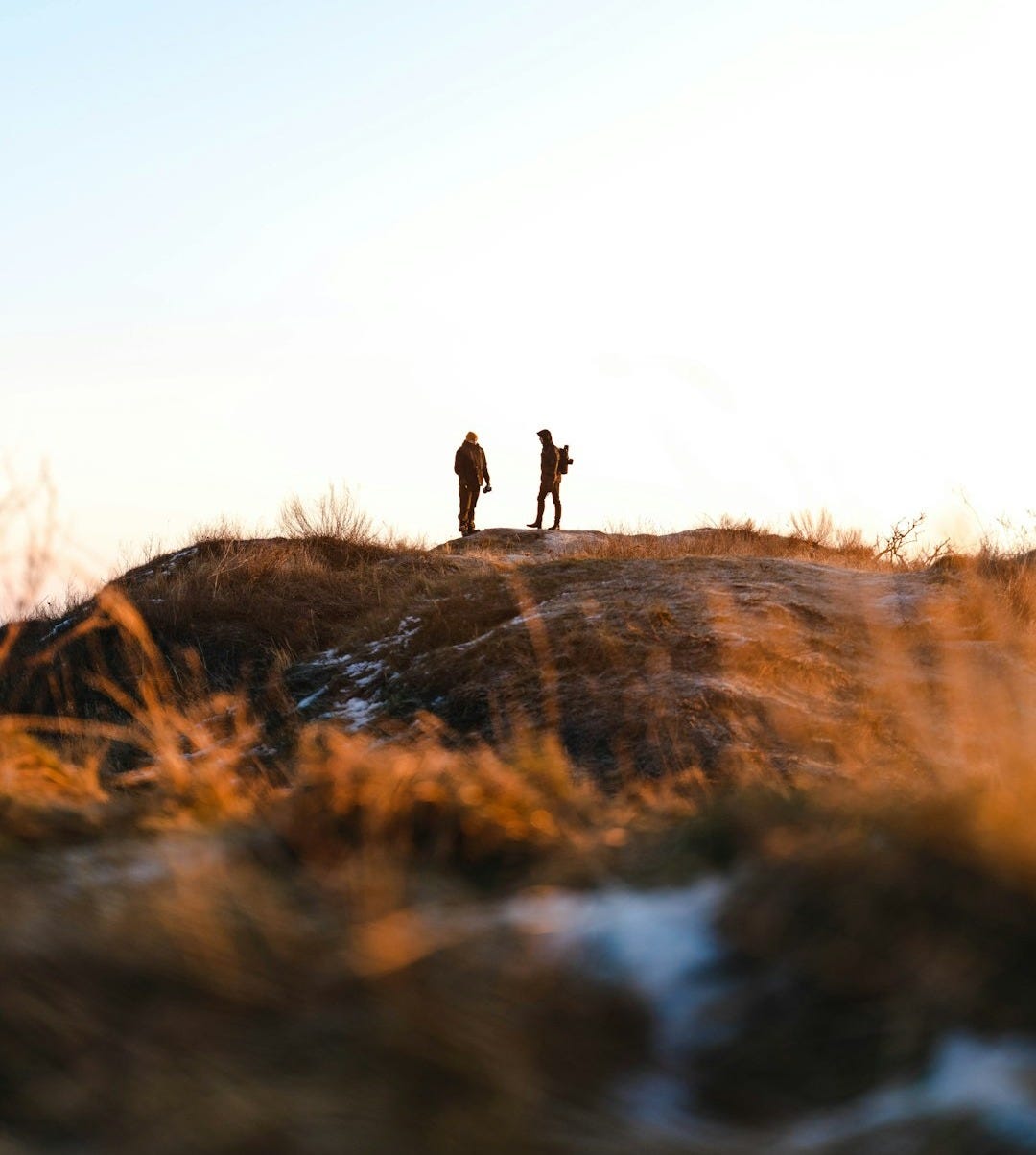 person walking on brown grass field during daytime