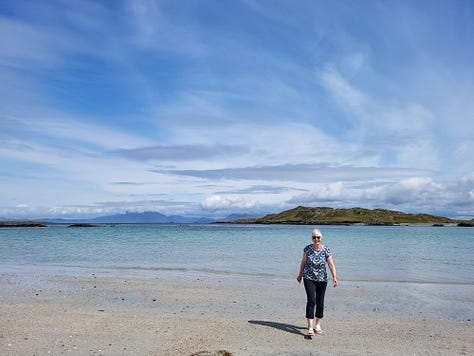 Map of Inishbofin, woman on beach, couple in boat.