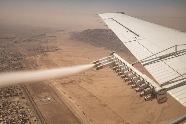 A spray of chemicals being emitted from the wing of an airplane.