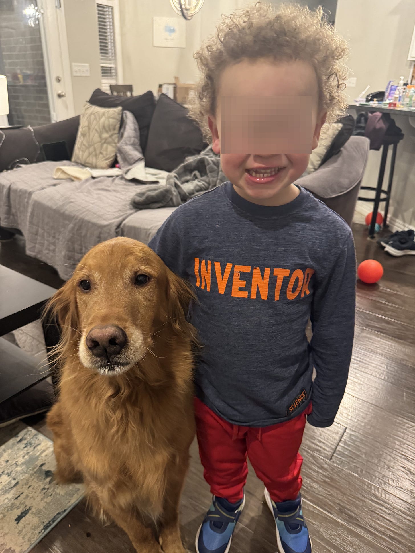 A golden retriever poses with a little boy for a picture