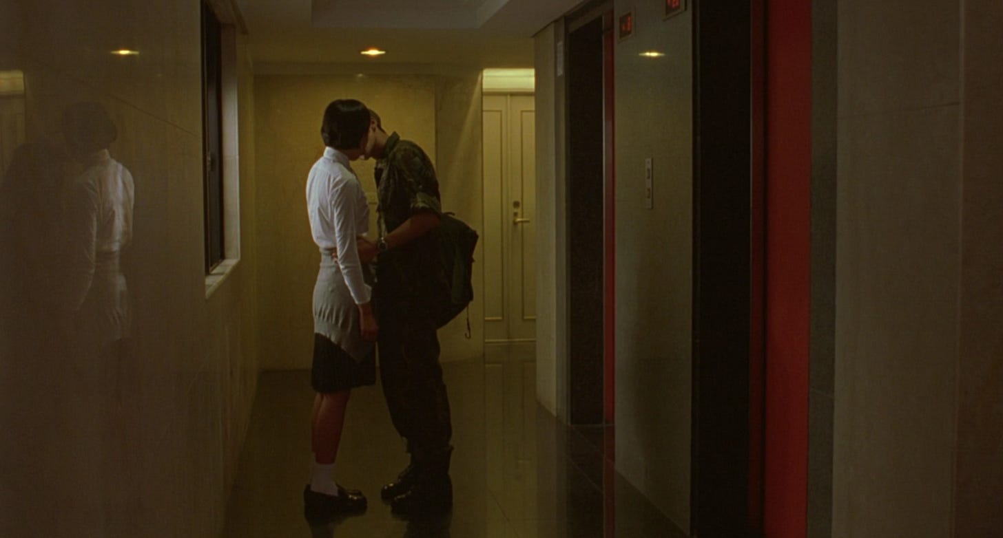 Lili and a man in a military uniform kiss outside of some elevators in Edward Yang's movie Yi Yi. 