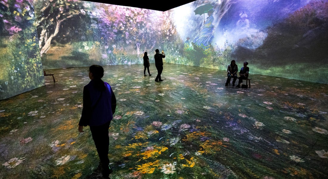 An immersive installation with painted flowers on with people standing around it