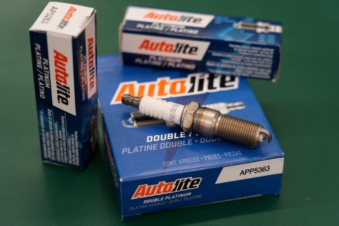 Autolite spark plugs on a box at an auto parts store.