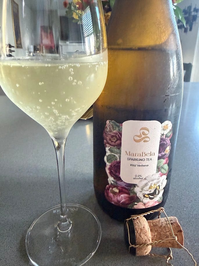 Two more non-alcoholic pours: MaraBela Wild Verbena Sparkling Tea poured beside its cork, and Serena Mode Rosé-Cinsault, a pale pink de-alcoholised wine, poured into a stemmed glass.