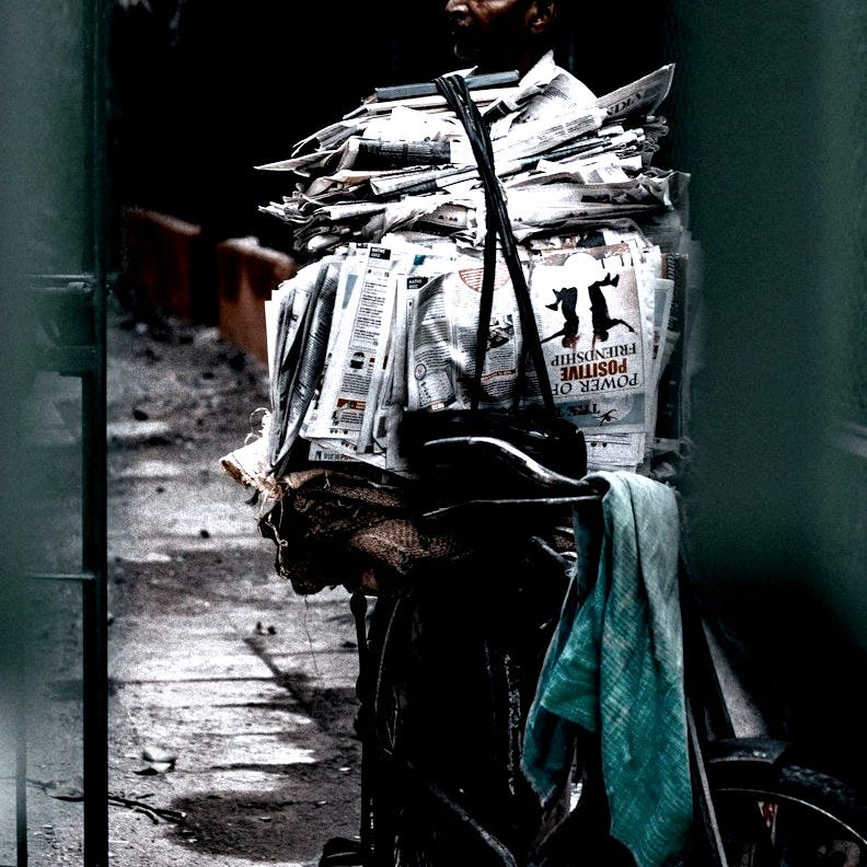 man near on pile of newspapers