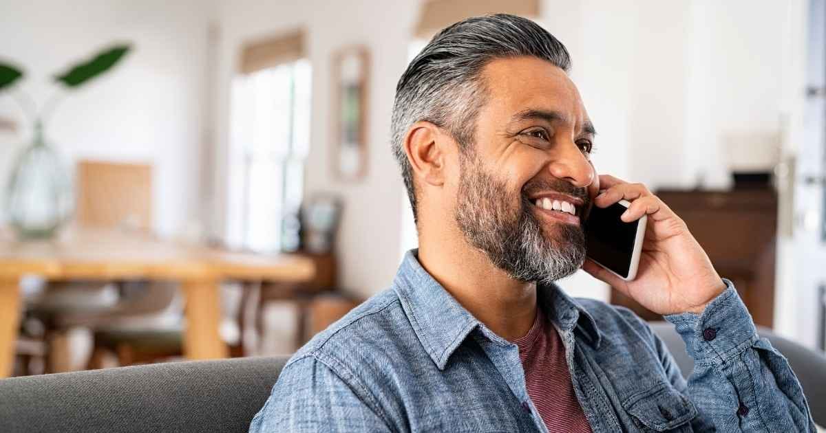 happy mid aged man talking on phone