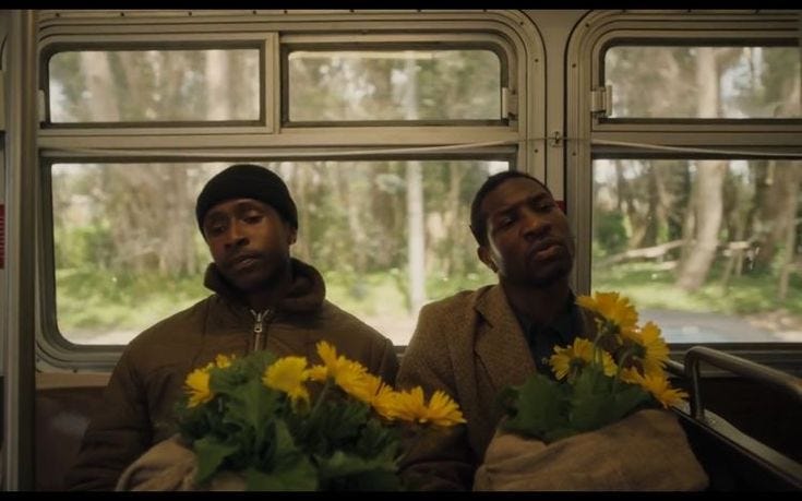 This may contain: two men sitting next to each other on a bus with flowers in front of them