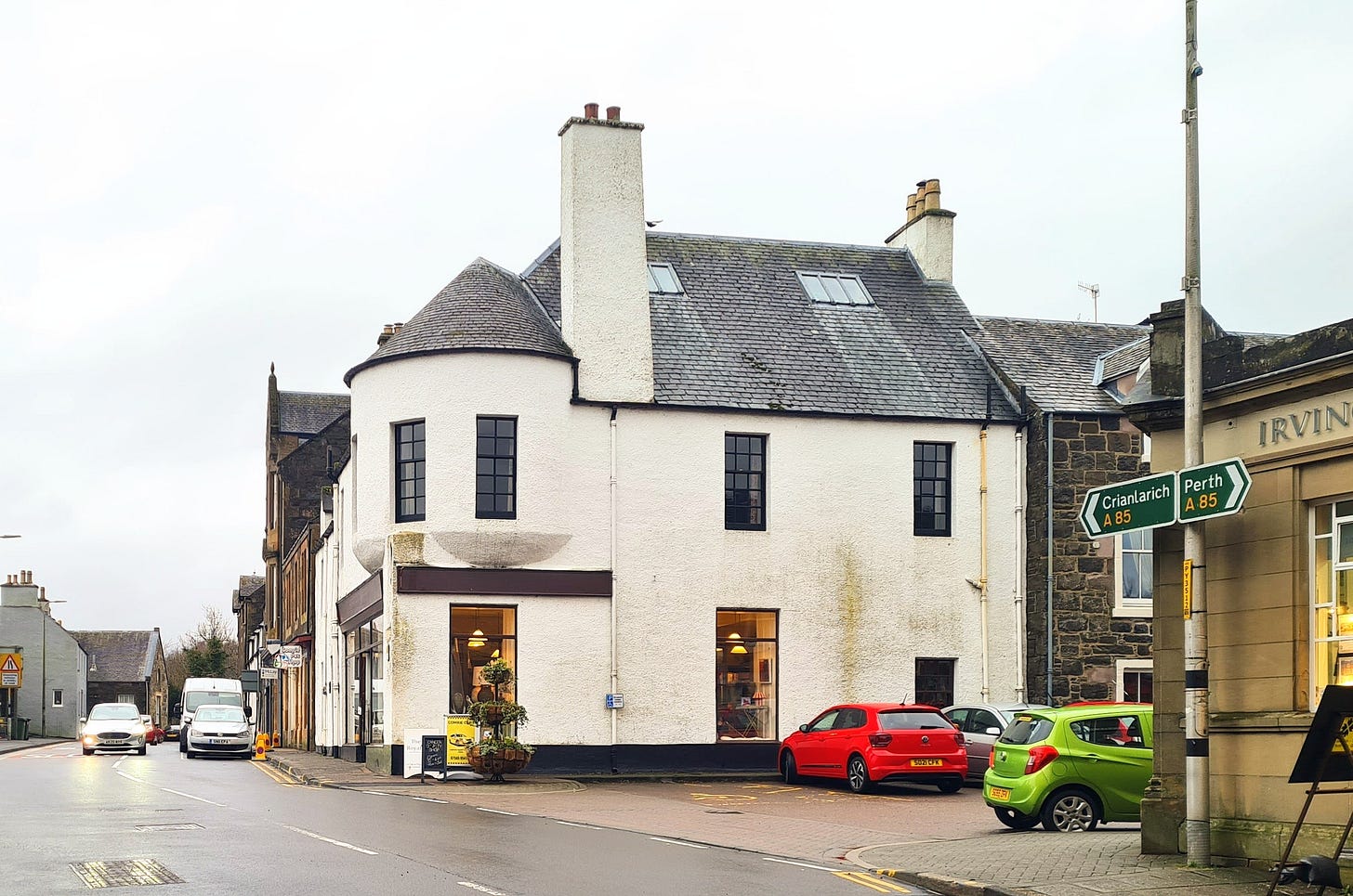 Photo of a white building with a turret on the corner of two streets in the Perthshire town of Comrie