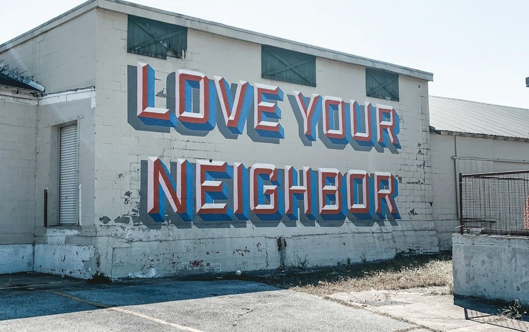a large sign on the side of a building that says love your neighbor a large sign on the side of a building that says love your neighbor