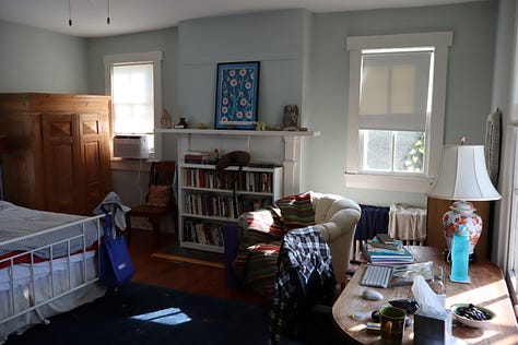 A road sign, a house number, a gate with stone pillars, a parlor with books and piano, a bedroom with writing desk