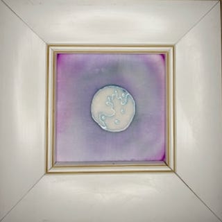 Framed silk painting of a moon against pink and blue gradient background