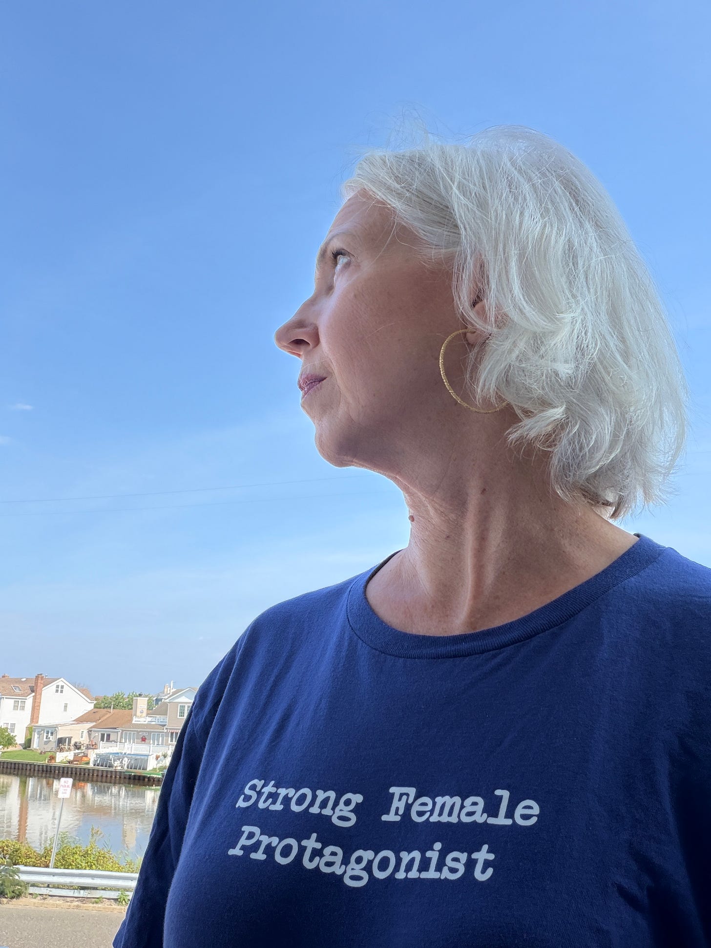 Woman with white hair wearing a blue t-shirt that reads "Strong Female Protagonist." Woman with white hair wearing a blue t-shirt that reads "Strong Female Protagonist."