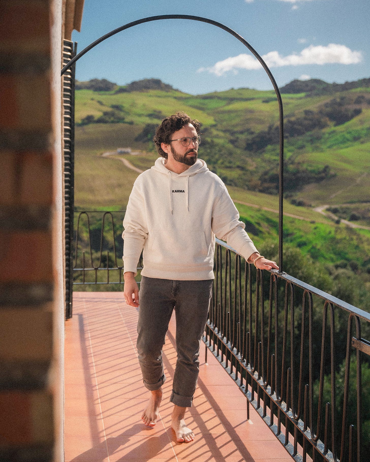 Person standing on balcony with mountains in the back