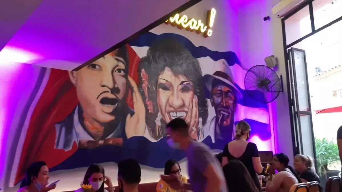 A group of people in a room with a mural on the wall

AI-generated content may be incorrect.