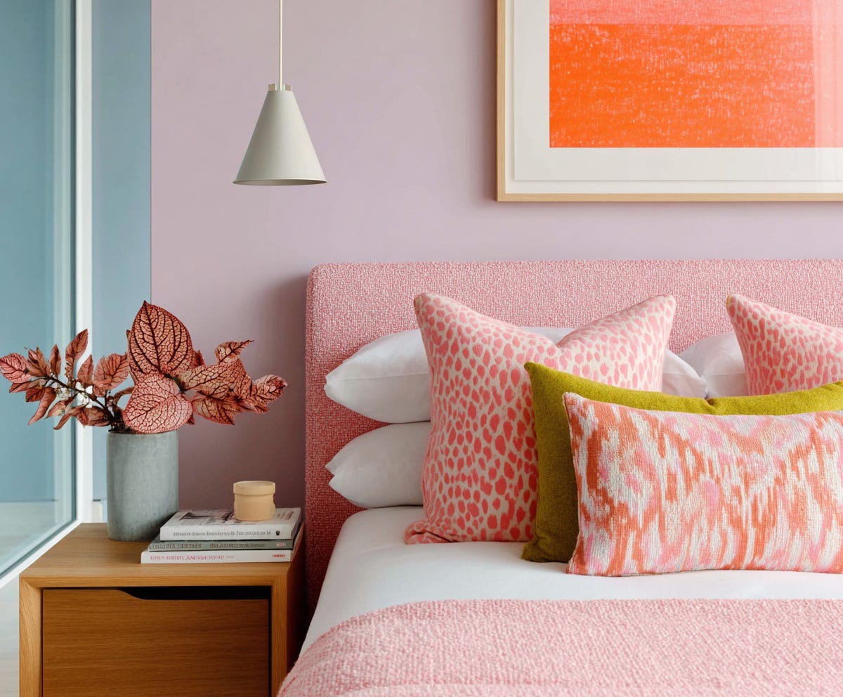 gorgeous bedroom in pink, orange, and chartreuse, with bedding in white and wooden side table, plush design interiors adelaide